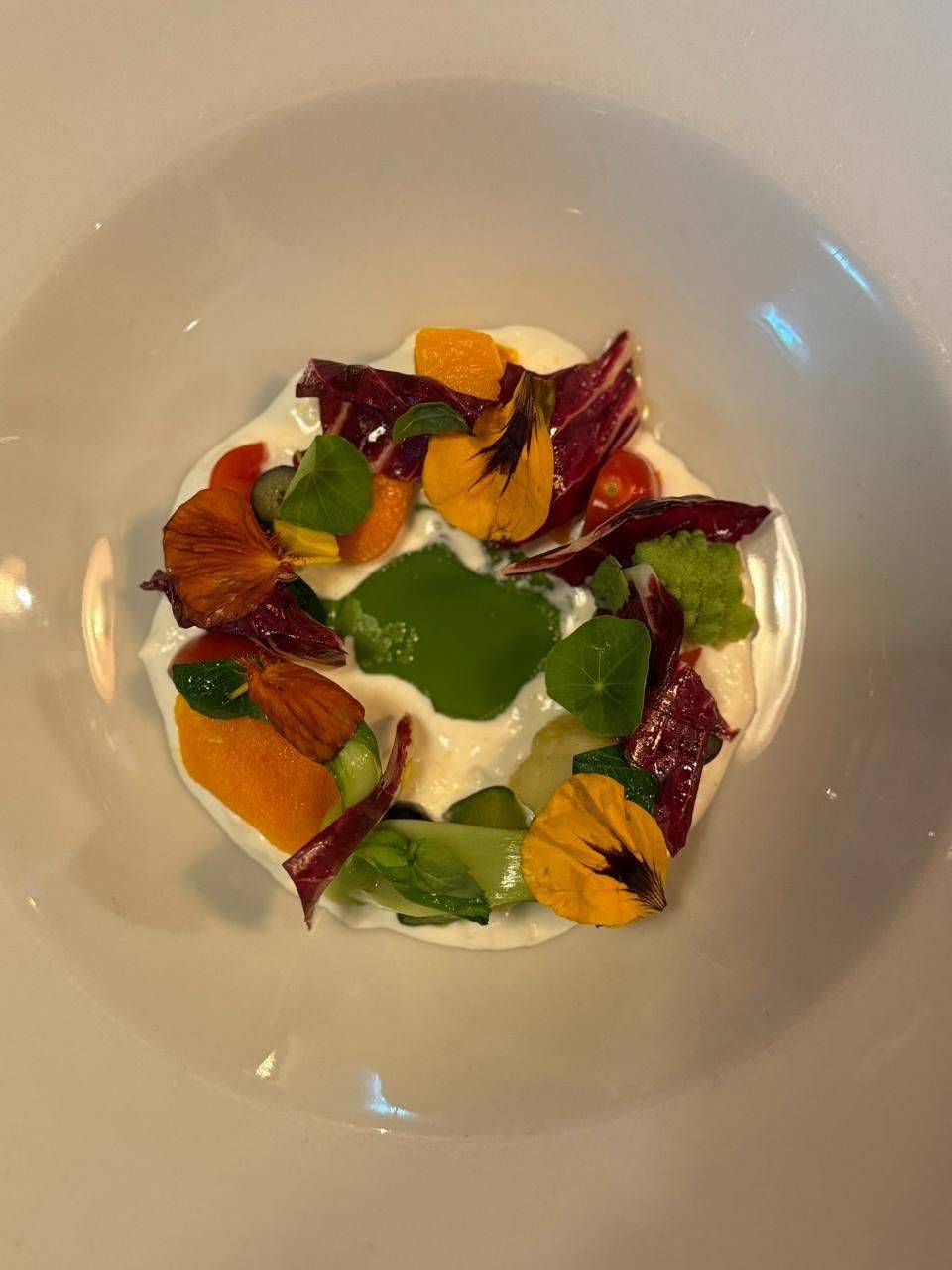 Un piatto con verdure, erbe e fiori commestibili